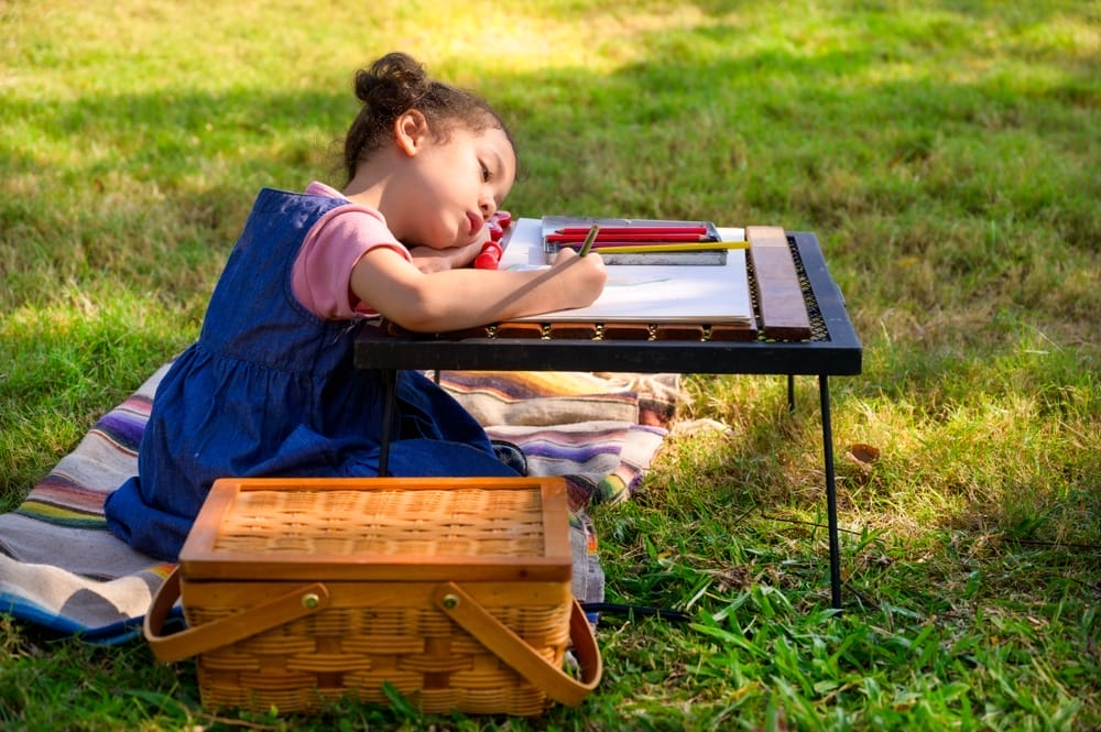 Little girl drawing outdoors