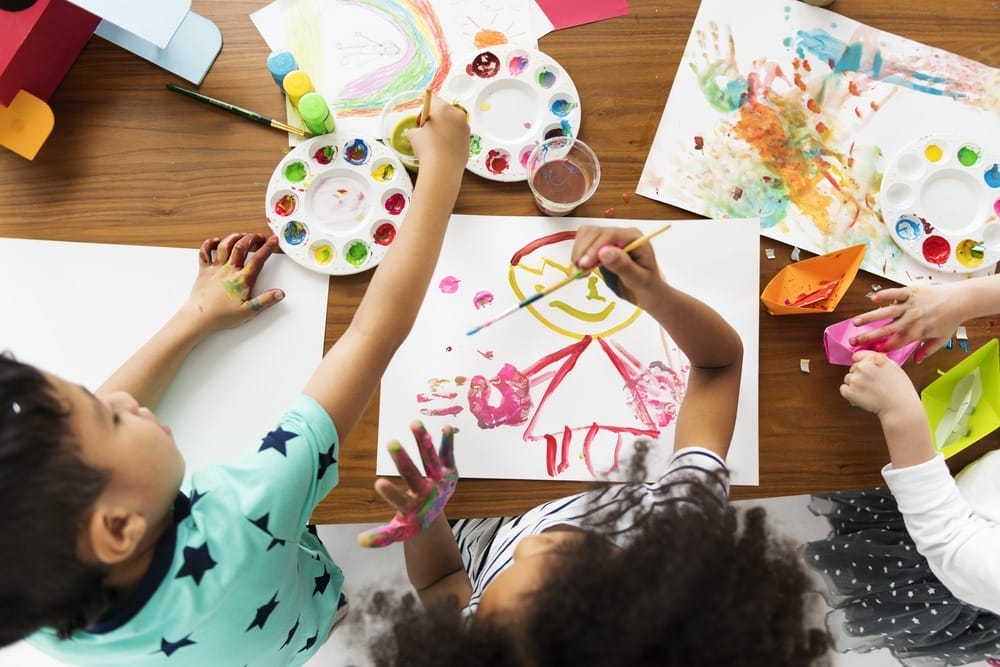 Cheerful cute kids having fun drawing