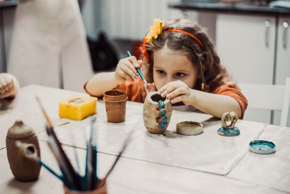 Child Sculpts Clay at Pottery School