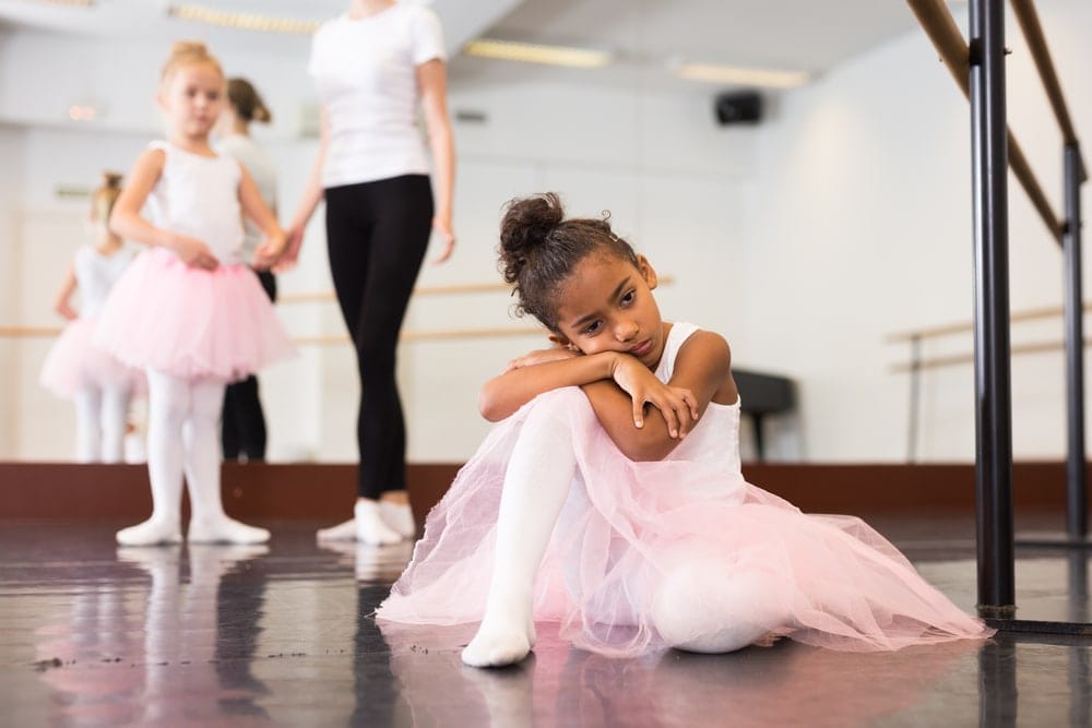 Portrait of sad and tired ballerina girl in ballet class