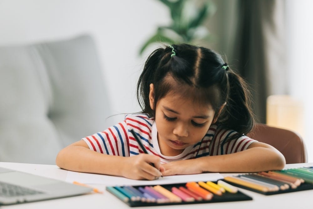 Child drawing with color pencils